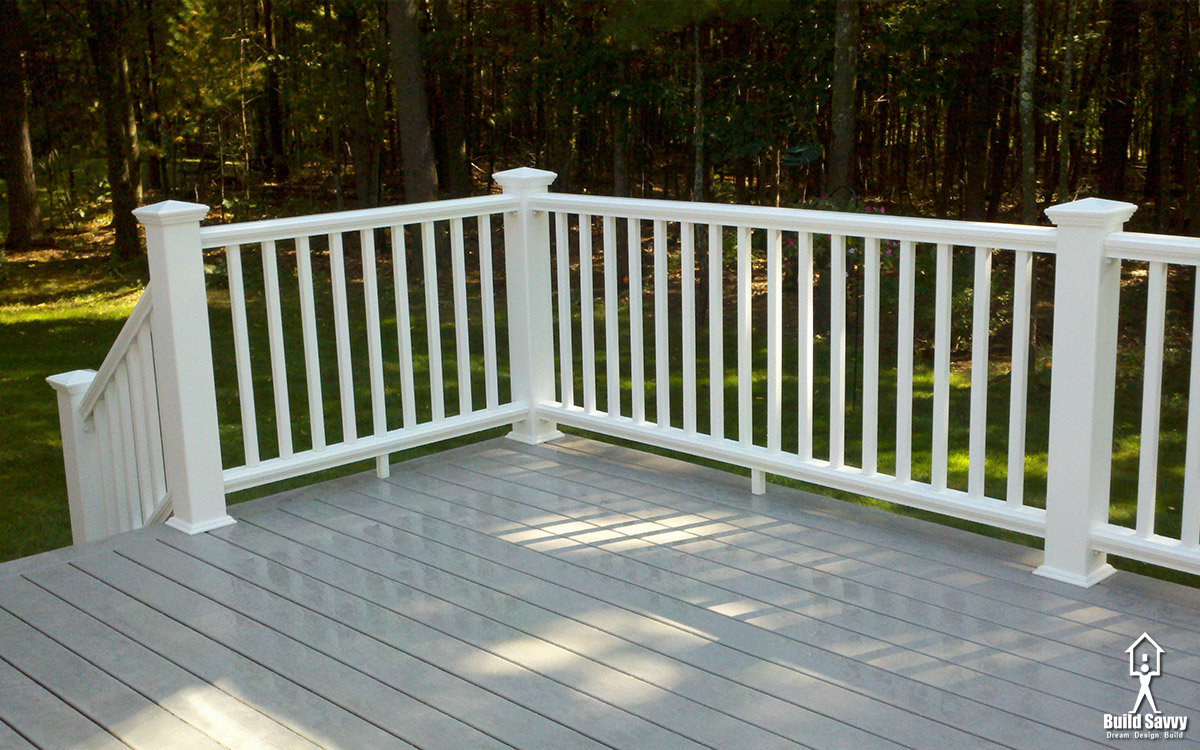 A close up shot of a white railed deck with grey floorboards