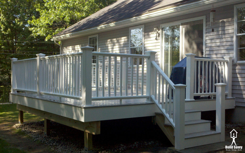 An angled 3/4 shot of a white railed deck with grey floorboards