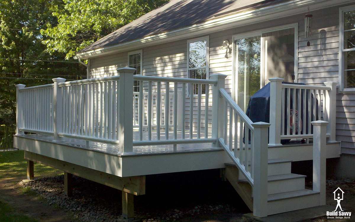An angled 3/4 shot of a white railed deck with grey floorboards