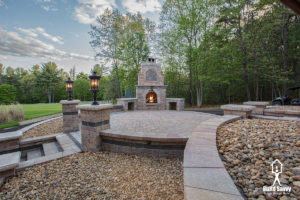 Custom stone patio construction with lit lanterns