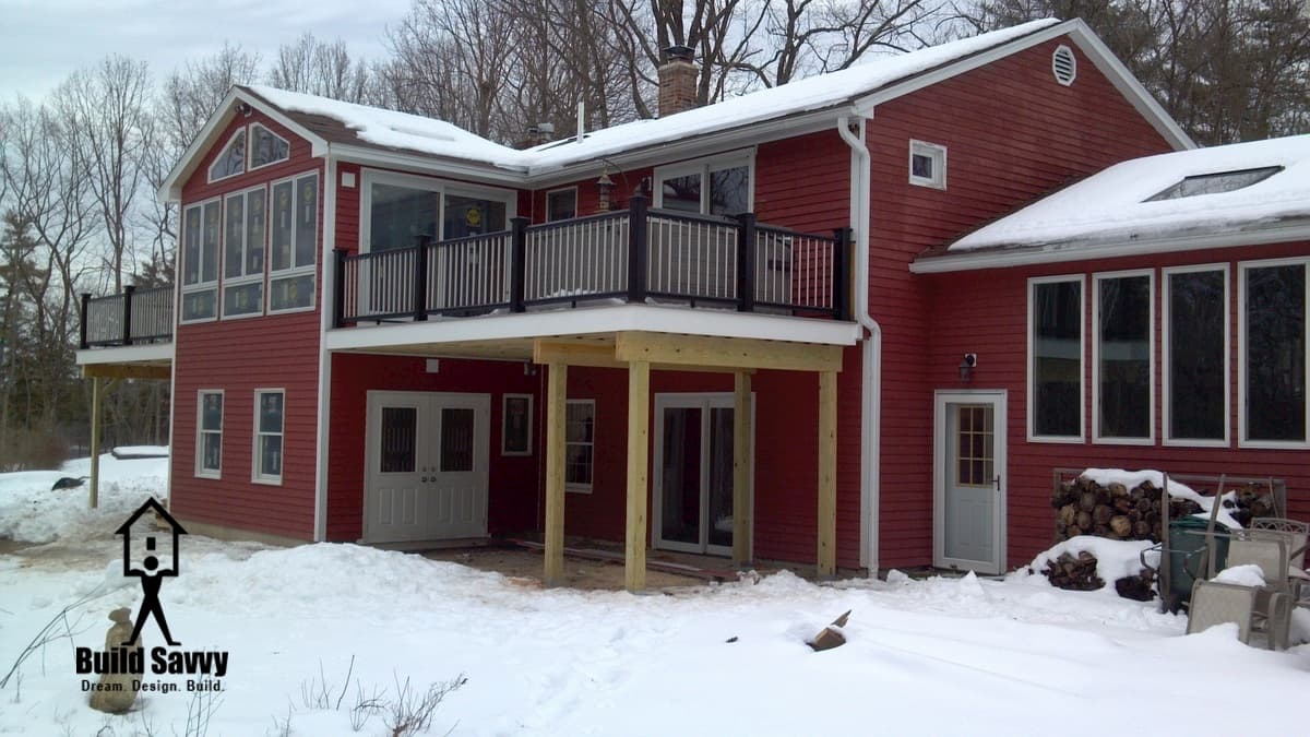 A red house with a black and white deck attached